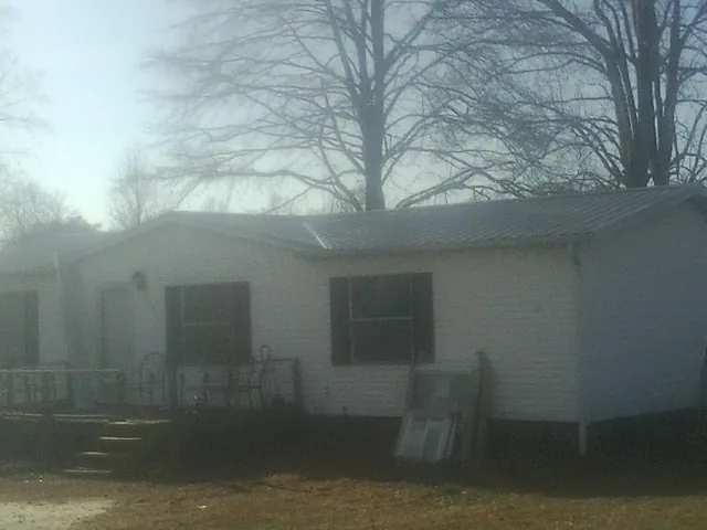 New metal roof on a white painted brick home on a foggy morning in Zion Grove